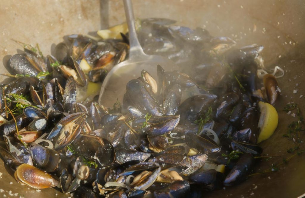 Mussels being cooked in a wok.