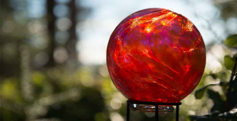Sunlight shines through a red glass ball.