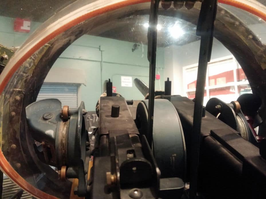 View inside the turret shows gun controls and guns pointed out the front.