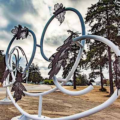 Metal leaves held in the air by curved white metal poles