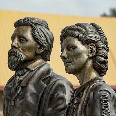 Bronze sculpture of pioneer couple dressed in pioneer era clothing