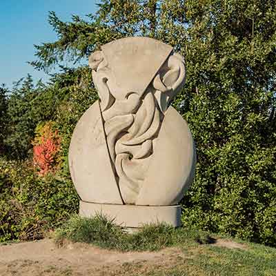 Stone sculpture of something escaping from inside a sphere