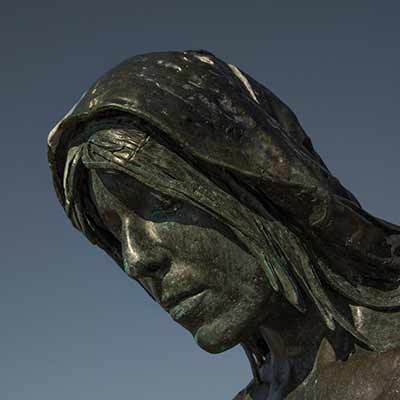 The face of a woman statue with a scarf over her head