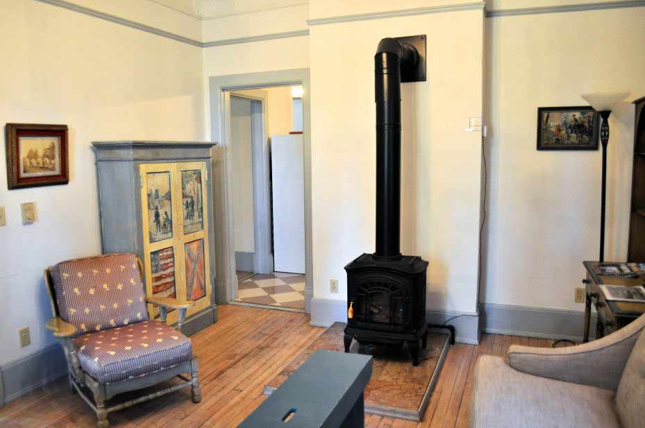 A living room with an old wood stove heater.