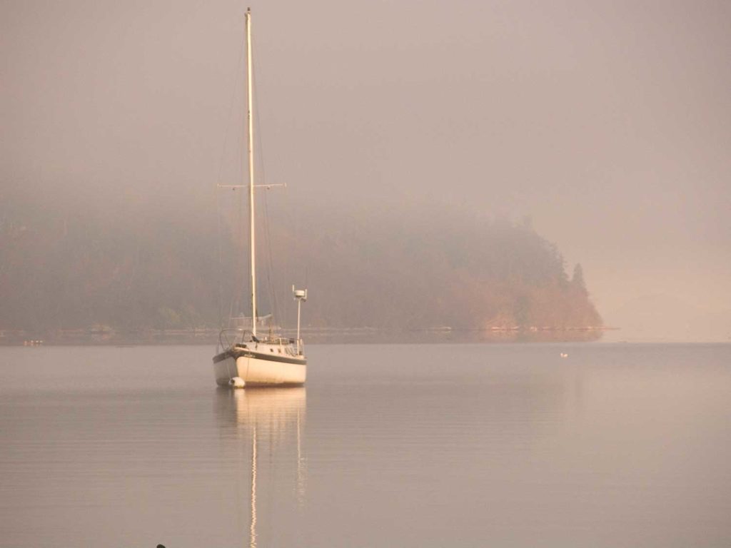 Sailboat at anchor in the fog.