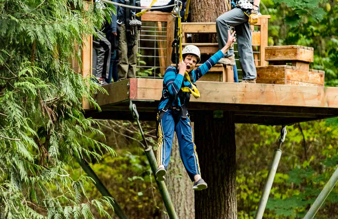 Young boy zip lining and having fun.