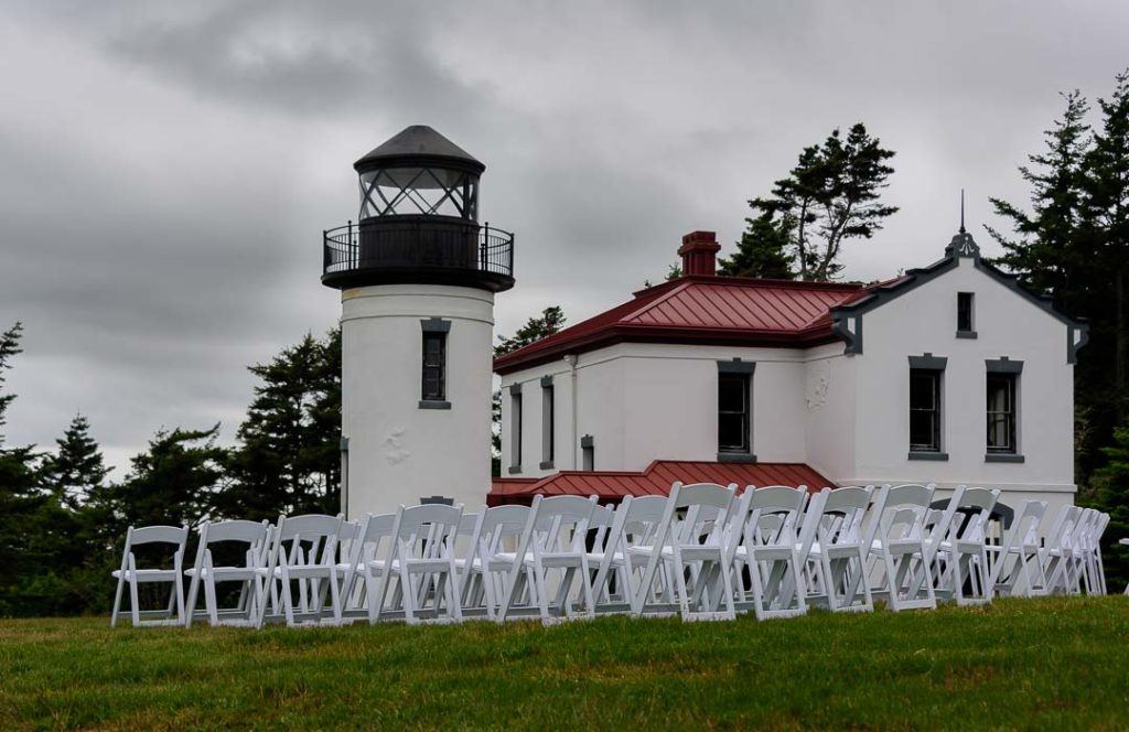 Lighthouse with wooden chairs arranged in rows on the front lawn