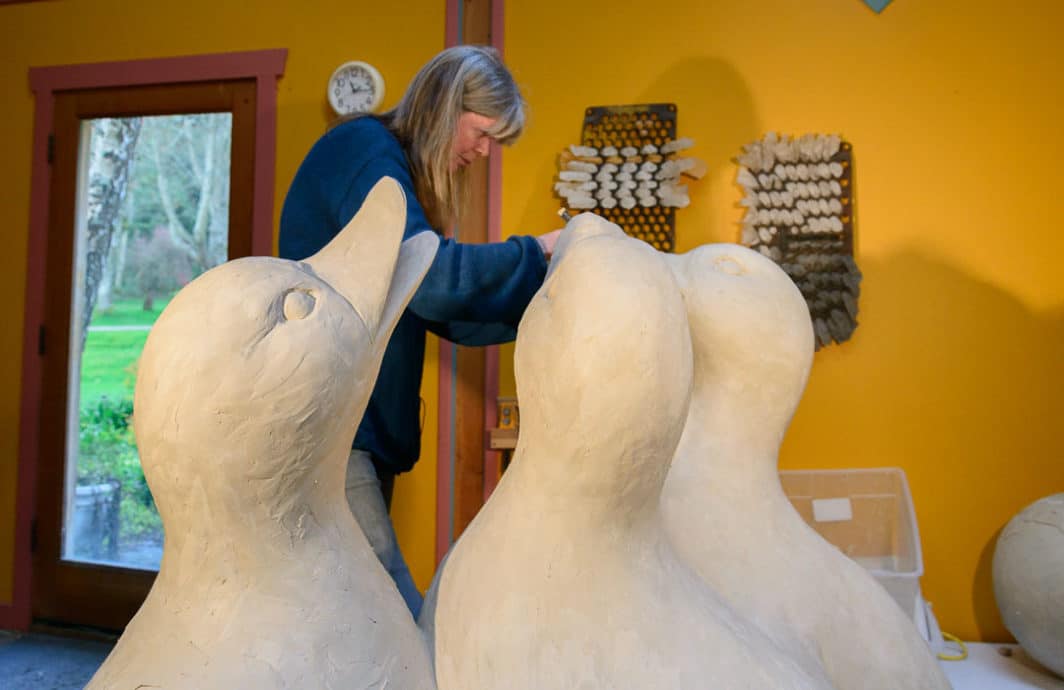 Sculptor Georgia Gerber works on giant clay ducks.
