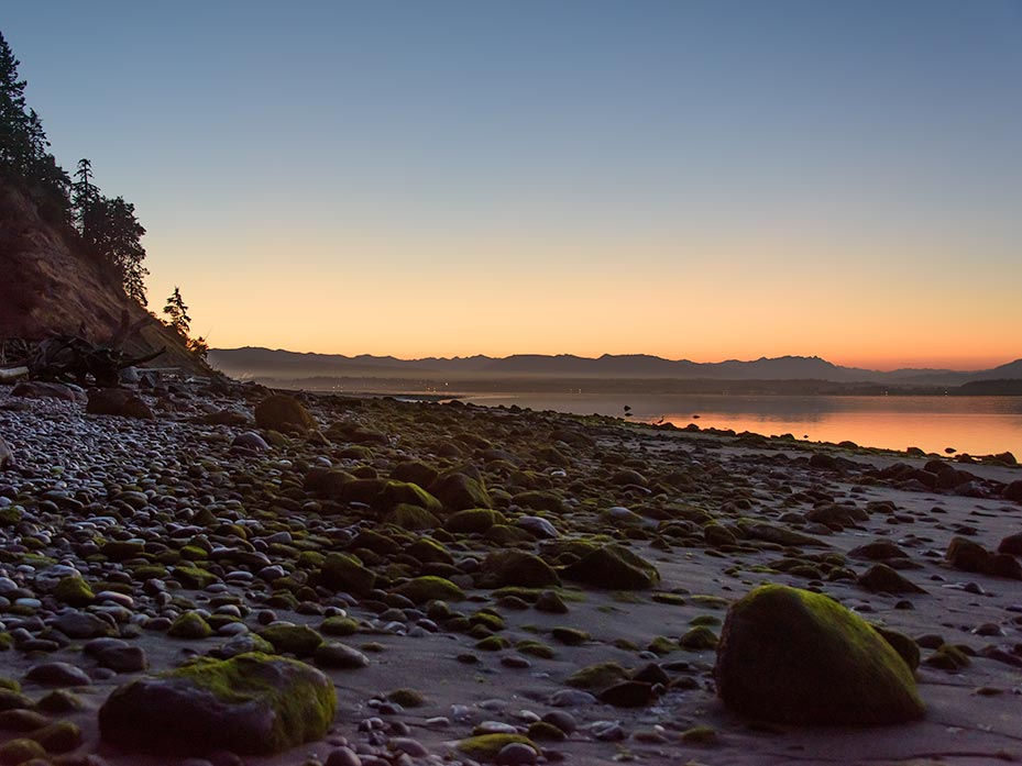 Rocks on a beach at low tide and at sunrise.