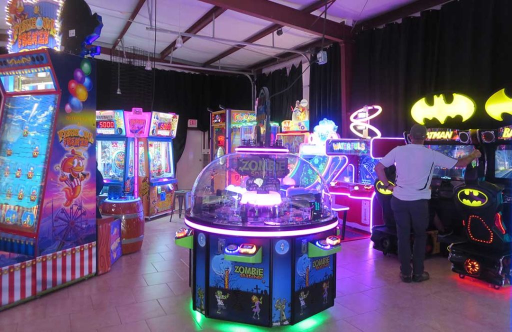 Several arcade games in a darkened room give the place a purple neon glow.