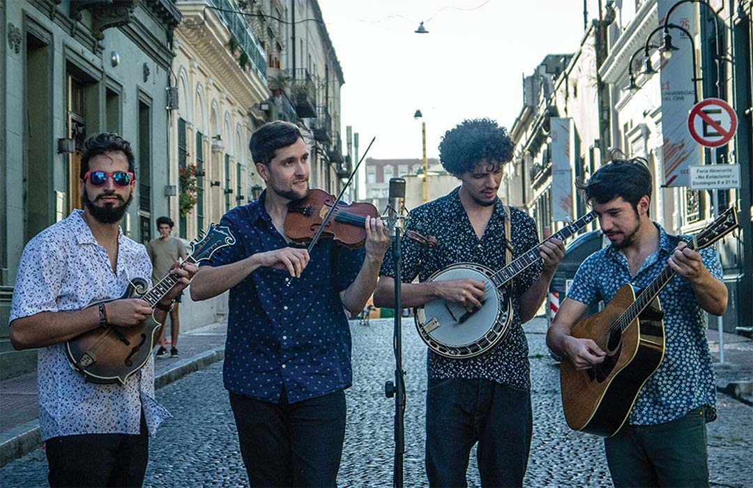 Four musicians playing their instruments in the street