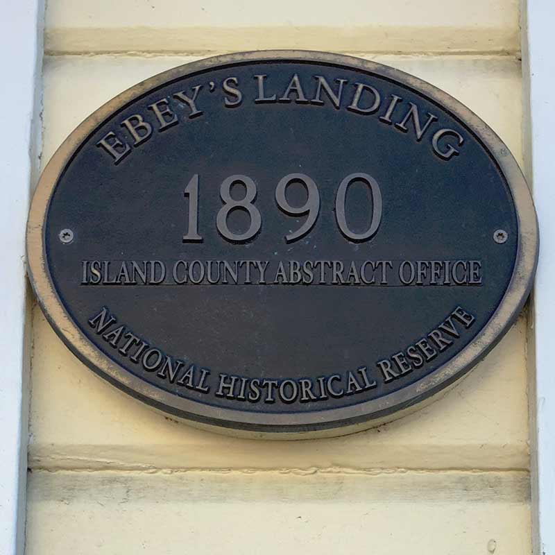 A brass plaque that says "Ebey's Landing 1890 Island County Abstract Office National Historical Reserve.