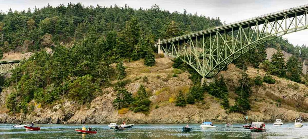 Fishing boats in Deception Pass. The view is from the water's edge.