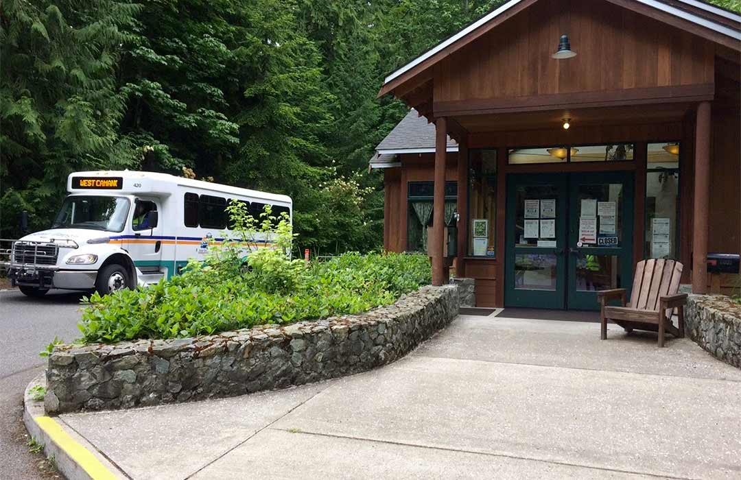 Island Transit bus and the exteior of a wooden building.