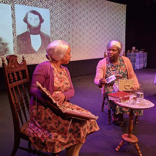 Two women in old-lady costumes sitting and talking.