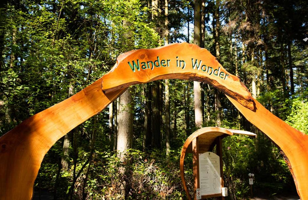 Large carved wooden arch that says "Wander in Wonder."