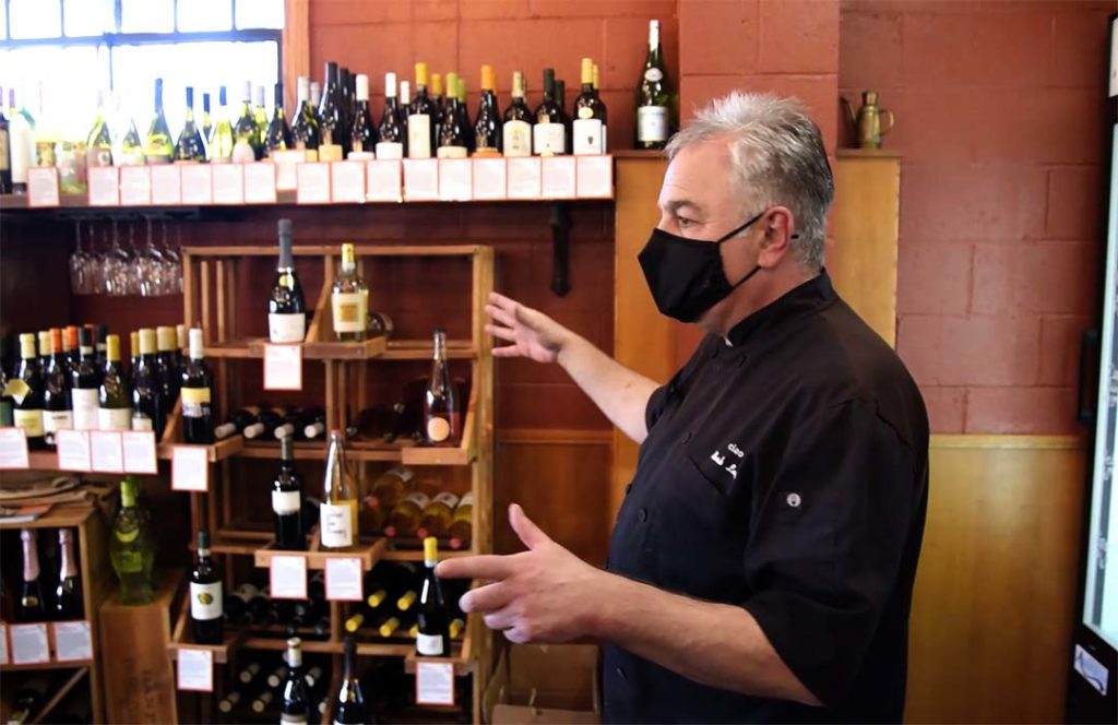 Mark Laska in the specialty store surrounded by bottles of imported wine.