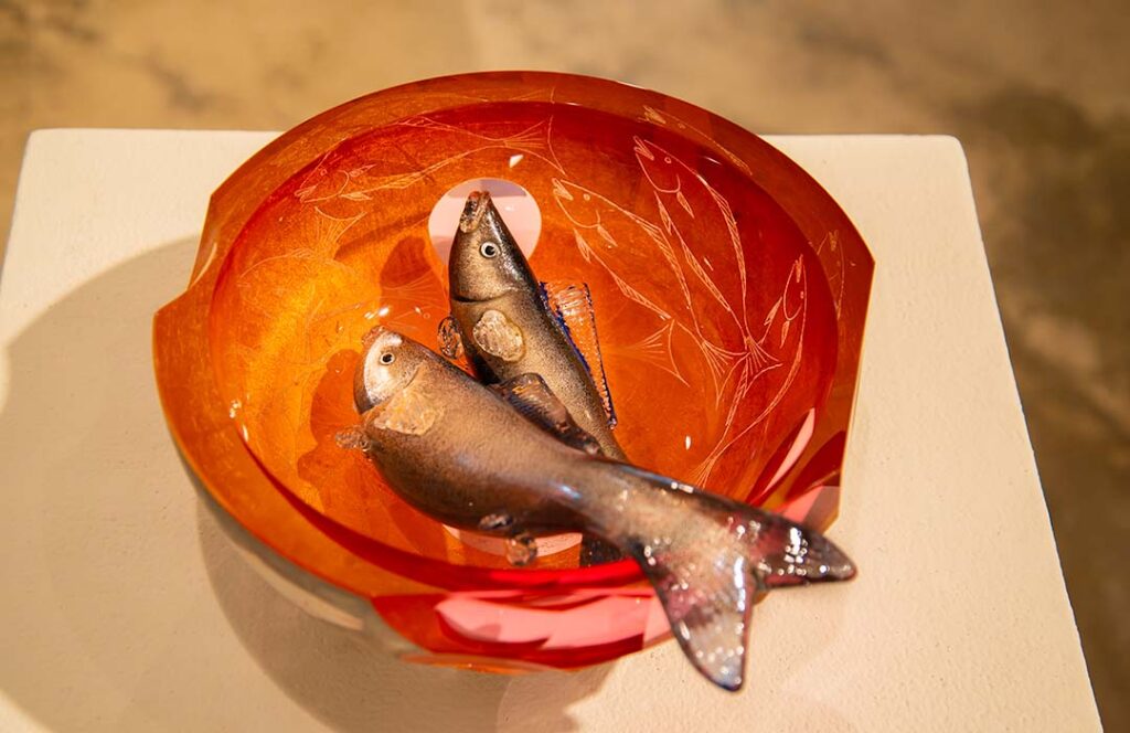 Two glass fish in a glass bowl.