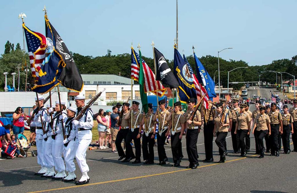 Color guards are marching to lead the Oak Harbor Independence Day Parade.