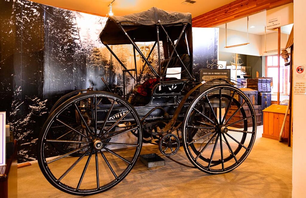 An old car that looks more like a buggy that would be pulled by horses.