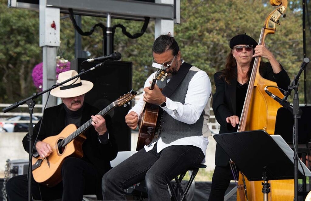 People playing musical instruments on an outdoor stage.