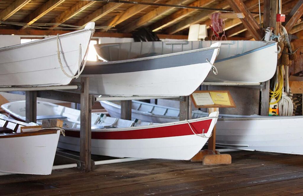 Six small wooden boats stored on a large rack.