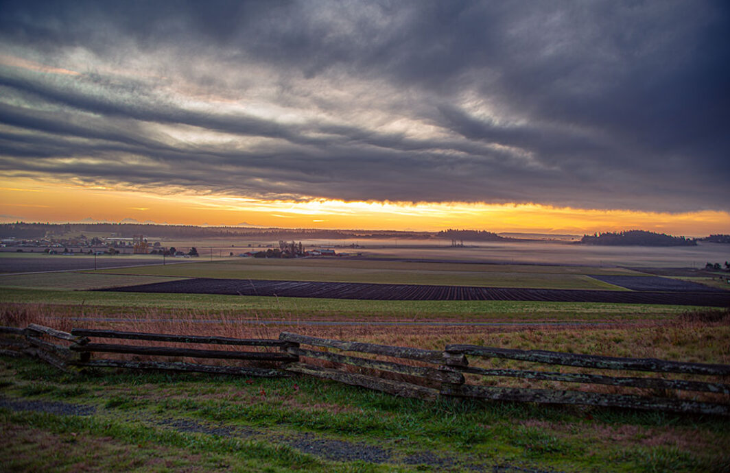 Dark clouds at sunrise highlight this view of the reserve farmland.