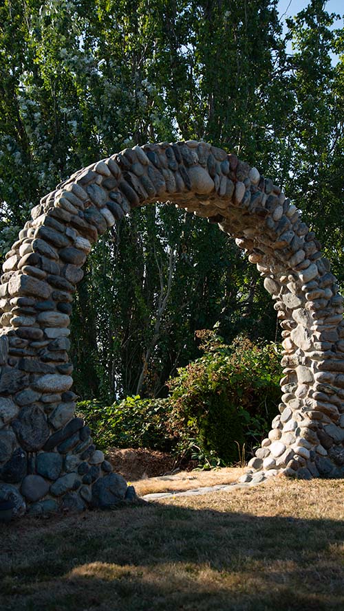 Archway is large enough for people to walk through and is made of rocks.