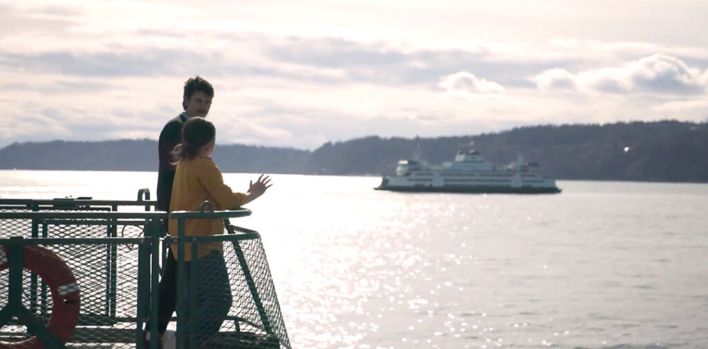 Couple on Washington State Ferry watching another Ferry pass by