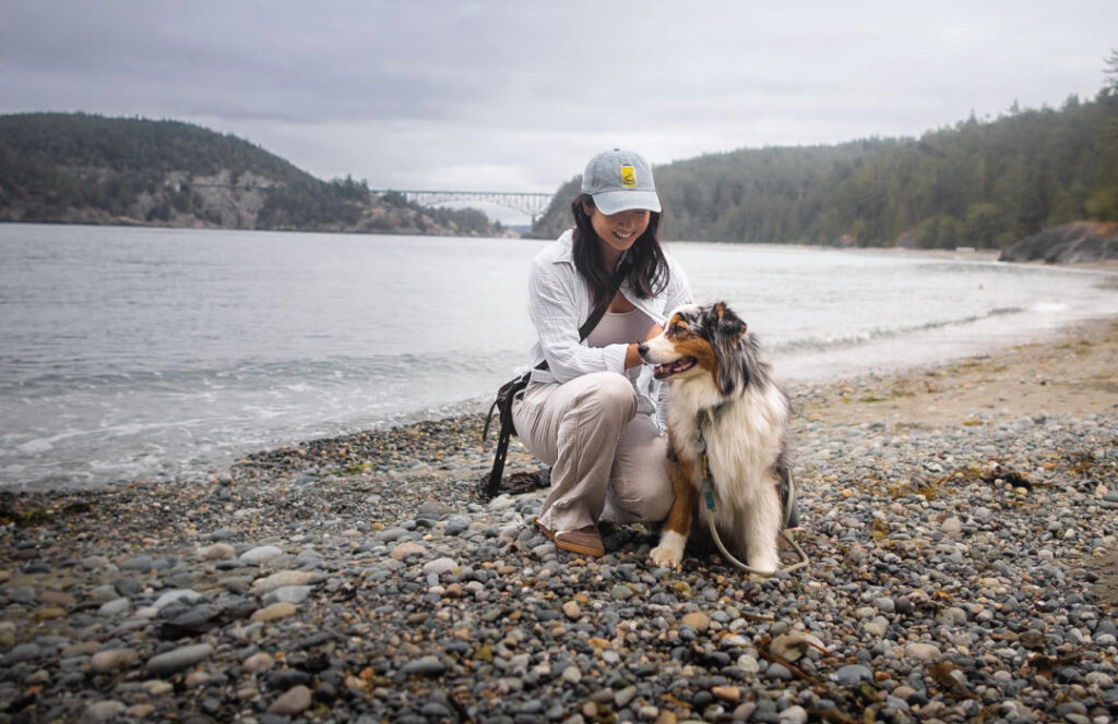 Melissa-Tang-and-her-dog-Koda-on--Deception-pass-beach-with-bridge-in-the-background-photo-Melissa-Tang-Digital-use-only