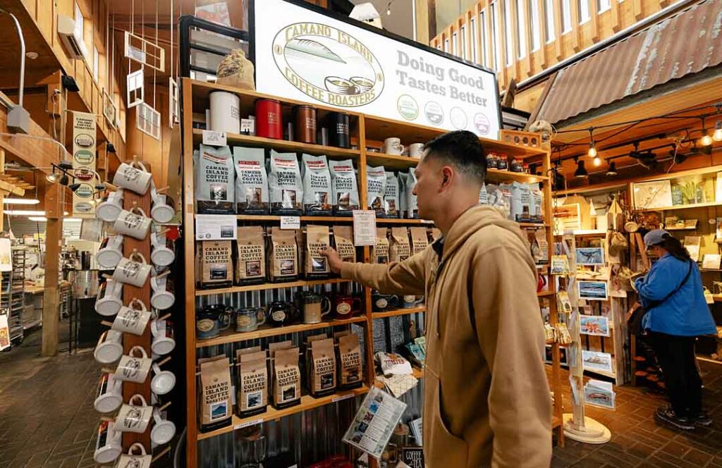 Man shopping at the Camano Marketplace - picking out some Camano Coffee Roasters coffee